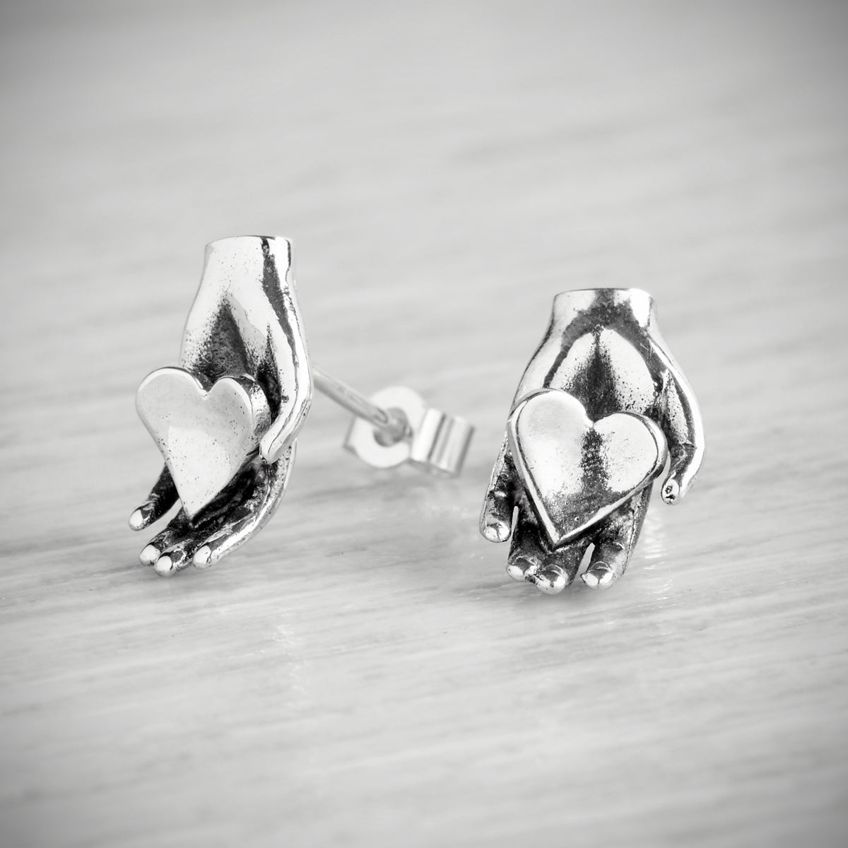 Tiny Heart in Hand Stud Earrings by Emma White