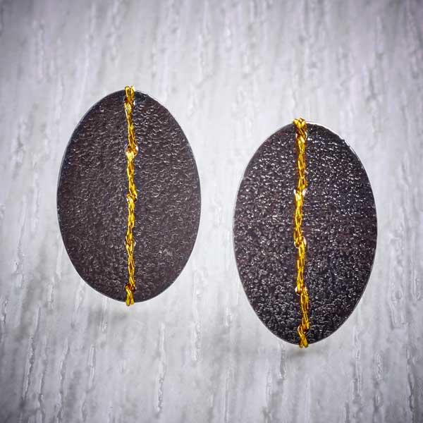 Oxidised (Blackened) Silver, Oval studs, sewn with Gold thread by Sara Bukumunhe. Image property of THE JEWELLERY MAKERS.-0