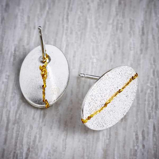 Silver sewn up textured stud earring with gold thread by Sara Buk. Image property of THE JEWELLERY MAKERS.-1