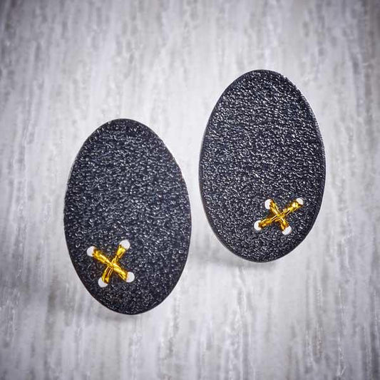 Oxidised (Blackened) Silver, Oval Studs with Tiny Gold Cross Stitch by Sara Bukumunhe. Image property of THE JEWELLERY MAKERS.-0
